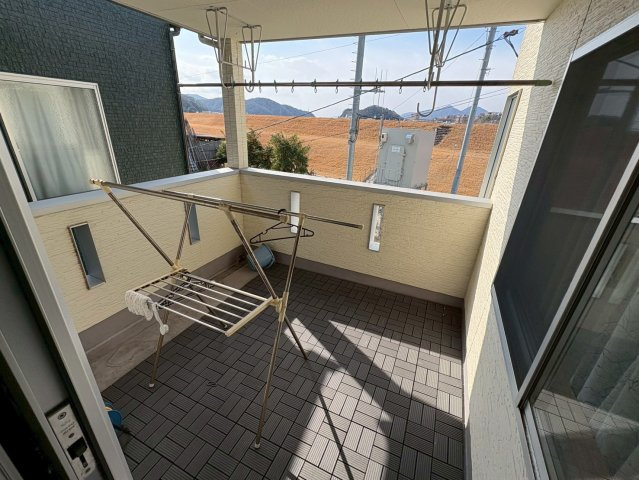 屋根付きで天候を気にせず、洗濯物を干すことができるバルコニーです。奥行きもあり、物干しスペースとして十分な広さを確保しています。外からの視線も気になりにくいため、日常使いしやすい空間です。