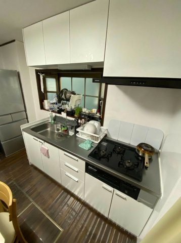 3口コンロと上下段収納。換気用の小窓で調理環境も良好。