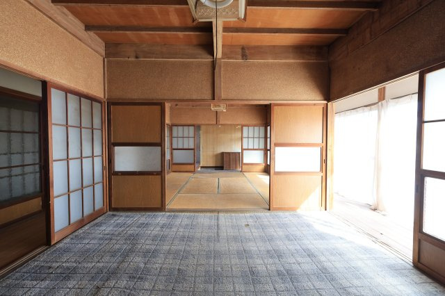 伝統的な梁が露出した天井構造、障子から光が入る和室