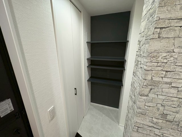 玄関横には可動棚付きの収納スペースを設け靴や傘アウトドア用品などを効率的に収納可能。ブラックの背面カラーが空間を引き締め全体に統一感を与えます。見た目もすっきりしており、実用性を兼ね備えた玄関収納。