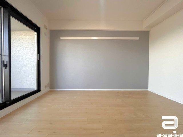 バルコニーに繋がる大きな窓から光が差し込む明るい部屋です。