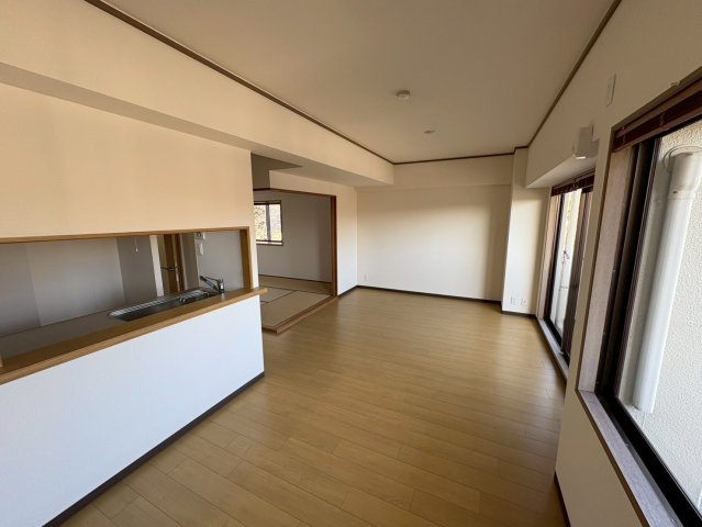 リビングダイニングは約13帖の広さがあり、家具配置がしやすい整形空間です。バルコニーに面した窓から自然光が入り、明るく開放感があります。キッチンは対面式で、リビングの様子を見ながら家事ができます。