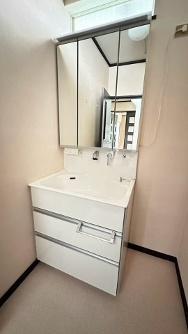 【使い勝手の良い三面鏡付き洗面化粧台】鏡裏収納と引き出し収納を備え、洗面小物や洗剤類をすっきり整理できます。広めのボウルで毎日の身支度や手洗いもしやすく、清潔感あふれる空間です。