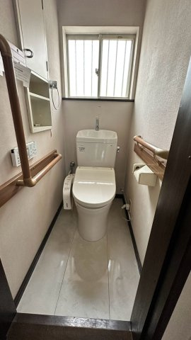 【手すり付きで安心の1階トイレ】両側に手すりを設置したバリアフリー配慮の安心設計。温水洗浄便座や壁面収納棚を完備しています。自然換気ができて手元も明るい小窓付きで、清潔感のある空間です。