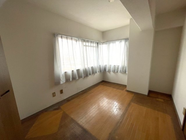 二面採光の明るい角部屋洋室。大きな窓から自然光がたっぷり入り、眺望も良好です。収納棚も完備されており、趣味のコレクションや日用品もすっきり整理できます。