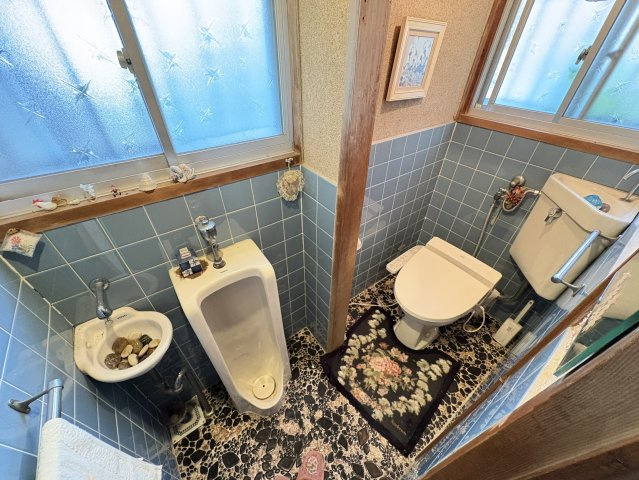 1階に設けられたトイレです。小便器と洋式トイレを分けて配置しており、来客時や家族の利用にも便利です。窓付きで換気もしやすく、リフォーム次第では、さらに使いやすい空間へと整えられます。