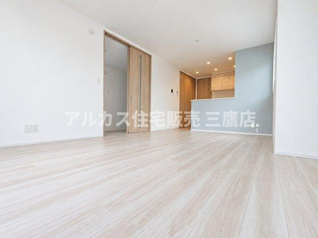 明るいナチュラルカラーのフローリングが美しい広々としたLDK。対面式キッチンの壁面に配されたアクセントクロスが、お部屋をおしゃれで洗練された空間に演出します。