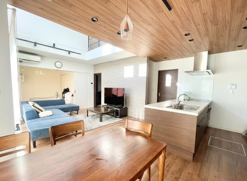 広々としたフラット対面キッチンが主役のLDK。ワイドなワークトップで調理や配膳がしやすく、家事効率がアップ。天井の木目パネルと統一されたデザイン性の高さが魅力で、空間全体が洗練された印象に！