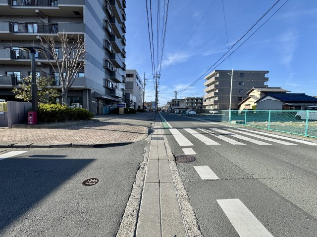 マンション東側の全面道路。こちら側から駐車場へ入ります。