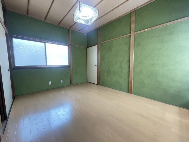 落ち着いた緑の塗り壁と木の柱が調和した、和モダンな雰囲気漂う洋室です。床は明るいフローリングでお手入れもしやすいデザイン。寝室や趣味部屋として活用できる一室。壁面の補修や照明の交換でより上質な空間に。