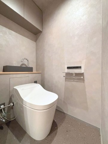 グレートーンに統一された落ち着いた印象のトイレ空間。人気のTOTO製品を採用。手洗い器付きです。