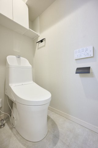 白ですっきりとまとめられた、スタイリッシュな温水洗浄便座付きトイレ。上部にはトイレットペーパーのストックや小物の収納に便利な棚を完備しており、限られた空間をスマートに美しく保てます。