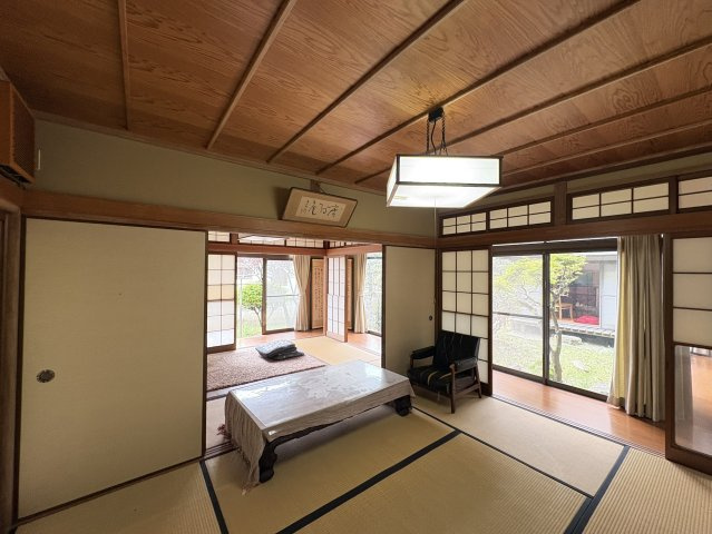 広々とした和室空間は、リビングとして家族がゆったりと過ごせる心地よい空間です。大きな窓からは庭の景色を楽しむことができ、室内にいながら自然を感じられる贅沢な設計です。隣接する和室と一体利用できます。