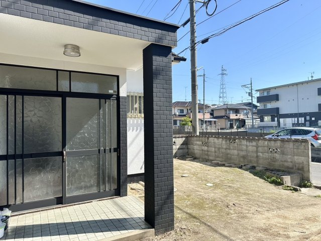 室外から見た玄関です。南向きで明るい玄関。白色の外壁に黒色の外壁がアクセントになっていますね。モニター付きインターホンで室内から来客の確認ができて、防犯面も安心。駐車場にはお車2台駐車可能ですよ。