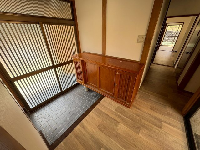 広さにゆとりのある玄関スペースになっております。。木製の下駄箱が設置されており、靴や小物をしっかり収納可能です。落ち着いた和の雰囲気があり、来客時にも好印象を与える玄関となっています。　