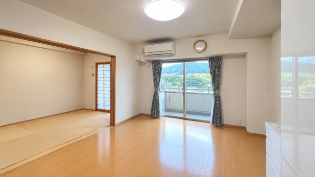LDKと隣接する和室を一体的に使える開放感のある住空間です。間仕切りを開ければリビングの延長として広々と使え来客時や家族が集まる場面にも便利。バルコニー側から光が入り先に広がる山並みも暮らしを彩ります