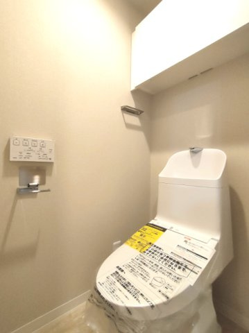 【トイレ】　スッキリとしたデザインの温水洗浄便座付きトイレ。小物やトイレットペーパーなどが目につかない状態で収納できます。