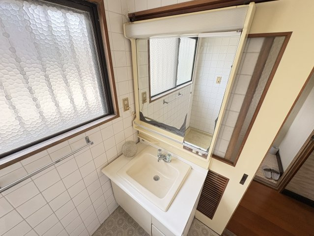 ゆとりあるスペースが確保された洗面室で、朝の身支度もスムーズに行えます。大きな鏡で使い勝手が良く、収納も備わっているため洗面用品の整理にも便利。窓付きで明るく清潔感のある空間となっております。