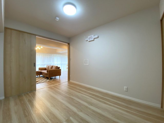 居室5.5帖　間取り図真ん中　木目調のフローリングと白いクロスが調和した洋室。どんなインテリアにも合わせやすいシンプルで使いやすいお部屋です。静かで快適なひとときを過ごせます。