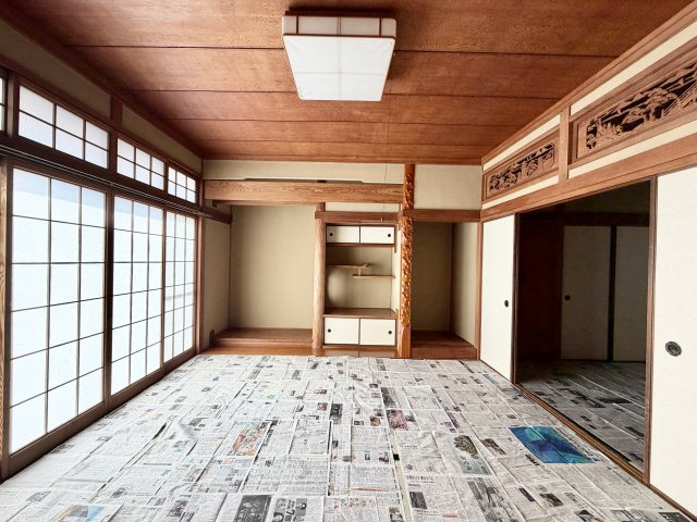 床の間や欄間が設えられた趣ある和室。大きな掃き出し窓からやわらかな自然光が入り、明るく開放的な空間です。押入収納も備わっており、来客用の客間や家族のくつろぎスペースとして活用できます。