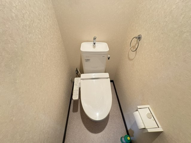 温水洗浄機能付きトイレを設置。シンプルで落ち着いた内装に仕上がっています。ペーパーホルダーやタオルリングも備えられ、使い勝手に配慮された空間です。独立した空間でゆったりとご利用いただけます。