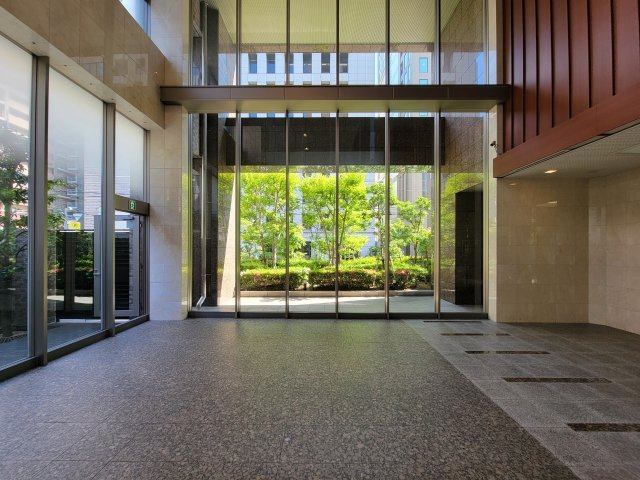 【エントランスホール】ガラス張りの開放的なエントランス！窓の外には緑豊かな植栽が広がっています！