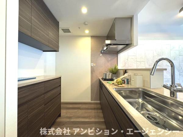キッチン背面には大容量の収納を完備。統一感のあるデザインで、生活感を隠してすっきりと保てます。