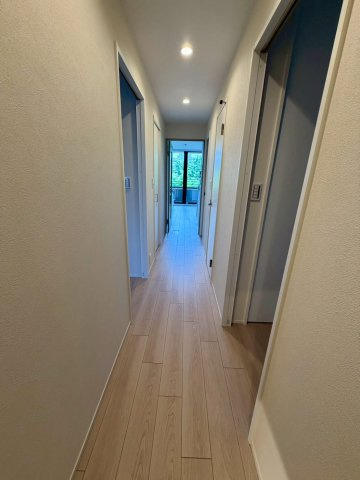 玄関からLDKまで続く直線の廊下。窓の外に見える緑が美しいです。