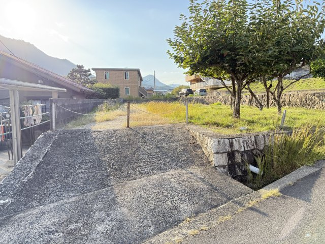 前面道路と敷地入口付近の様子です。第一種低層住居専用地域に位置しており周辺は静かな住宅環境が広がる落ち着いた街並み。広い敷地を活かして平屋住宅や庭付きの住まいなどゆとりある住まいづくりを検討できる土地