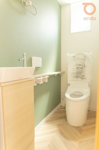 【ondo建物プラン例/トイレ】　手洗い場付きのトイレは衛生面にも配慮。緑のアクセントクロスが空間のアクセントに◎