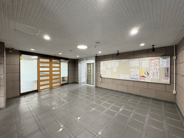 広々としたエントランスホールは、清潔感と開放感のある空間。ガラス扉と木目調のアクセントが温かみを添え、訪れる人を心地よく迎え入れます。掲示板にはお知らせや管理情報が整理され、管理体制の良さが伺えます。