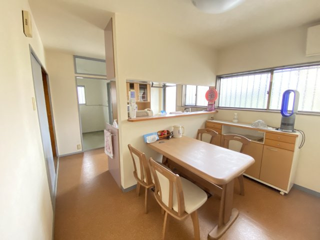 ダイニングキッチンは木目調の温かみある空間で、落ち着いた食事時間が過ごせます。カウンターキッチンを採用しており、配膳や会話がしやすく、家族とのつながりを感じられる設計。光が差し込む明るい室内です。　　