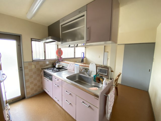 収納力たっぷりのシステムキッチンは、調理・片付けもスムーズに行えます。ピンクを基調とした可愛らしいカラーが、日々の料理時間を楽しくしてくれます。勝手口もあり、ごみ出しや買い物帰りの動線も良好です。　　