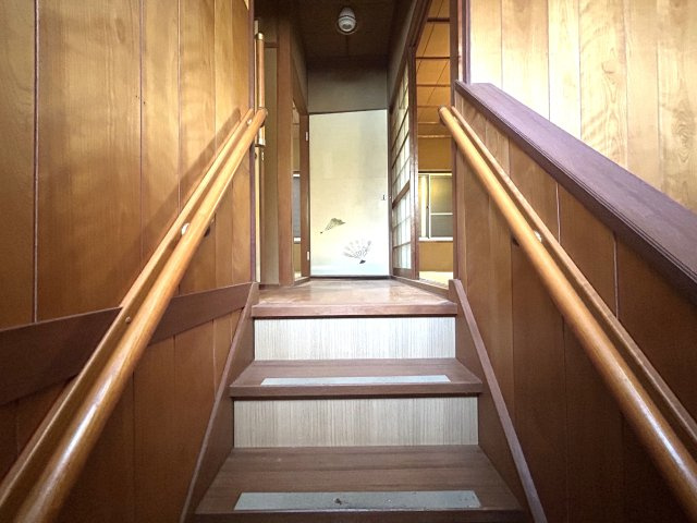 両側に手すりを設置した階段。木目調の壁が温かみを演出します