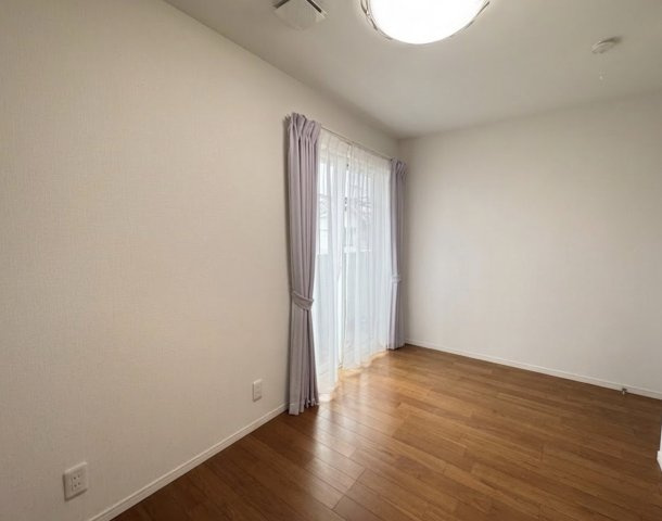 大きな掃き出し窓から自然光がしっかり差し込む明るい洋室です。フローリング仕様でお手入れもしやすく、寝室や子供部屋としても使いやすい空間。シンプルな内装のため、家具の配置やインテリアのアレンジも自由。