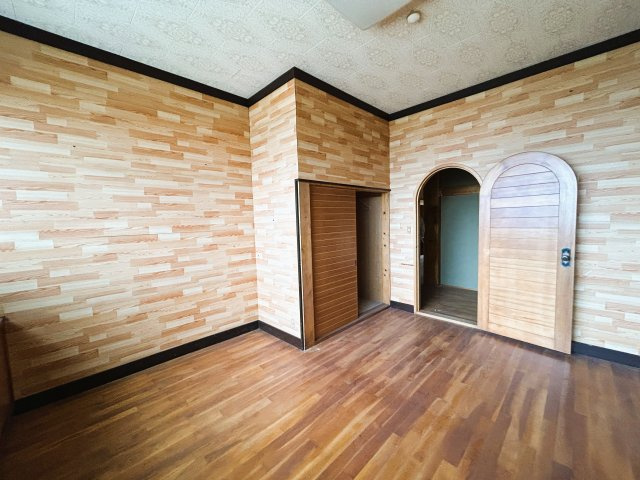 アーチ型の扉が目を引く洋室。異なる木目柄を組み合わせた内装