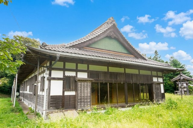 青空に映える瓦屋根が、伝統的な和の趣を演出する外観