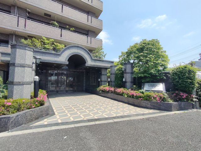 【エントランス】　重厚な石造りのアーチと季節の花々が、まるで邸宅のような趣を感じさせます。