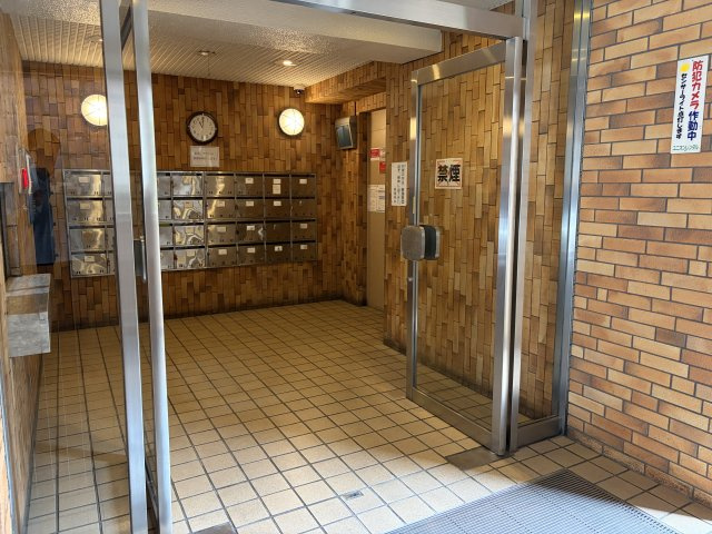 ブラウン調のタイル貼りがクラシカルな雰囲気を醸し出すエントランスホール。防犯カメラ作動中でセキュリティ面も配慮されており、集合ポストも完備された整然とした安心の共用空間です。