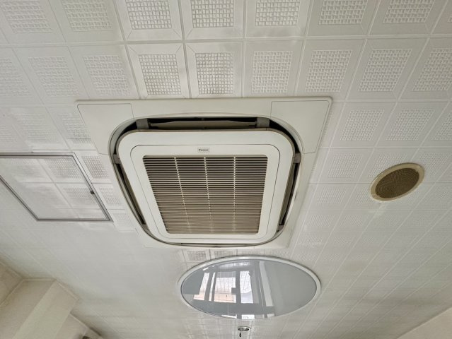 天井埋込型の業務用空調設備を採用しており、広い室内でも効率よく冷暖房を行える設計です。空間全体へ均一に空気を循環させやすく、来院者や利用者が快適に過ごせる環境づくりに役立ちます。