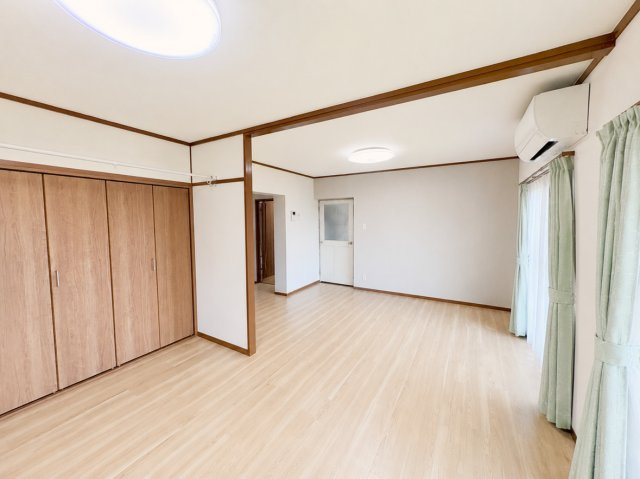 広々としたリビングダイニングです。壁一面に大型のクローゼットを完備しているため、お洋服や日用品をすっきり収納でき、お部屋を最大限広く使えます。（CG加工による家具消しを行っております。）
