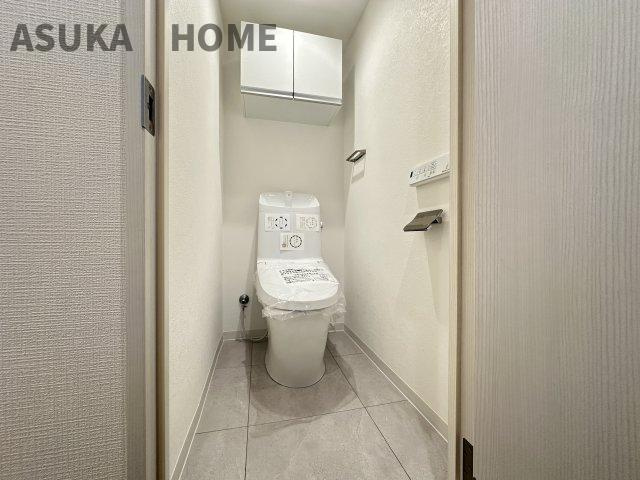温水洗浄便座の最新トイレ設備。奥行きの有るトイレスペース、吊戸棚があり収納も◎　