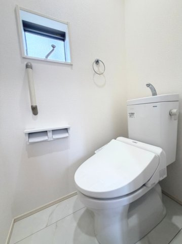 【1階トイレ】　手すり付きで安心の1階トイレ。トイレは温水洗浄便座付です。小窓もあり換気も良好です。
