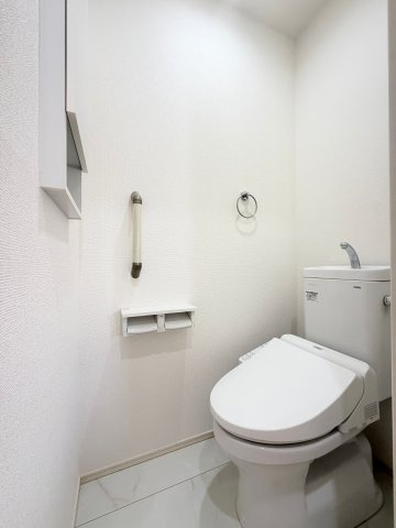 【2階トイレ】　収納棚や手すりを備え、使いやすく配慮された2階トイレです。トイレは温水洗浄便座付です。