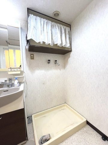 防水パンを備えた洗濯機置場には上部収納を設け、洗剤や日用品をすっきり整理できます