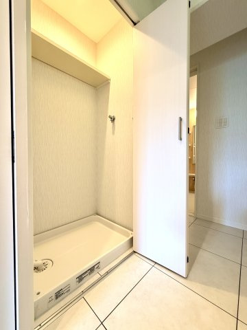 【室内洗濯機置き場】　室内の雰囲気を損なわないよう隠せるうえに、稼働中の音を聞こえにくくする扉付きです。
