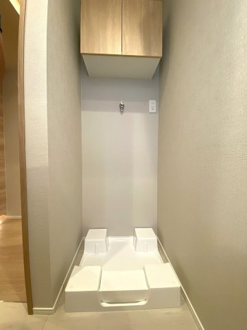 洗濯機置場の上部や周辺には洗剤等を置ける便利なスペースがあり、日々の洗濯作業をスムーズに行えます。清潔感のあるデザインで日常の家事を気持ちよくサポートします。