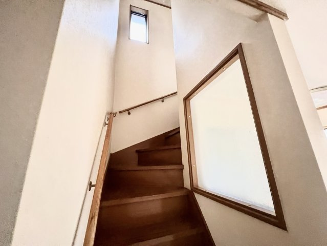 木の温かみを感じられる階段には手すりが設けられており、上り下りをサポートします。階段上部には窓があるため自然光が入りやすく、明るさを確保できる造りです。高さもあり、開放感が感じられます。
