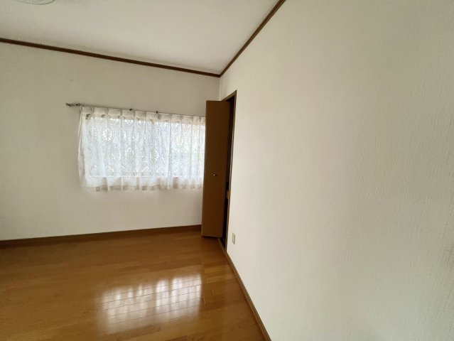 2階に配置された6帖の洋室です。窓から自然光が差し込み、明るさを感じられる室内。木目調のフローリングで、収納スペースも備えており、衣類や日用品を整理しやすく、寝室や子ども部屋など幅広く活用可能です。