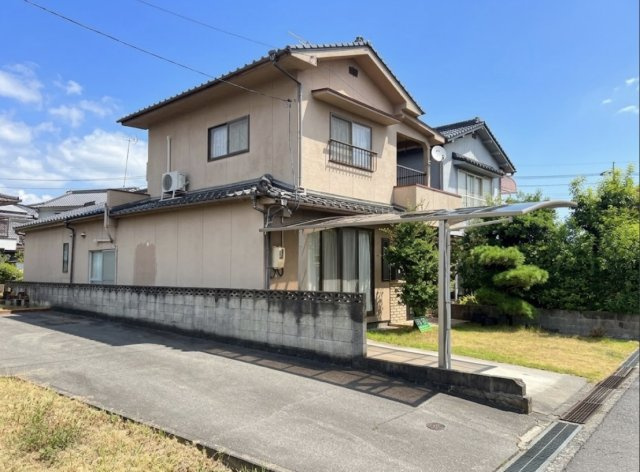 外壁と瓦屋根が調和した、和の趣を感じる戸建住宅です。敷地内にはカーポート付きの駐車スペースや庭があり、戸建ならではのゆとりを感じます。2階には屋根付きのベランダを備え、実用性にも配慮された住まいです。